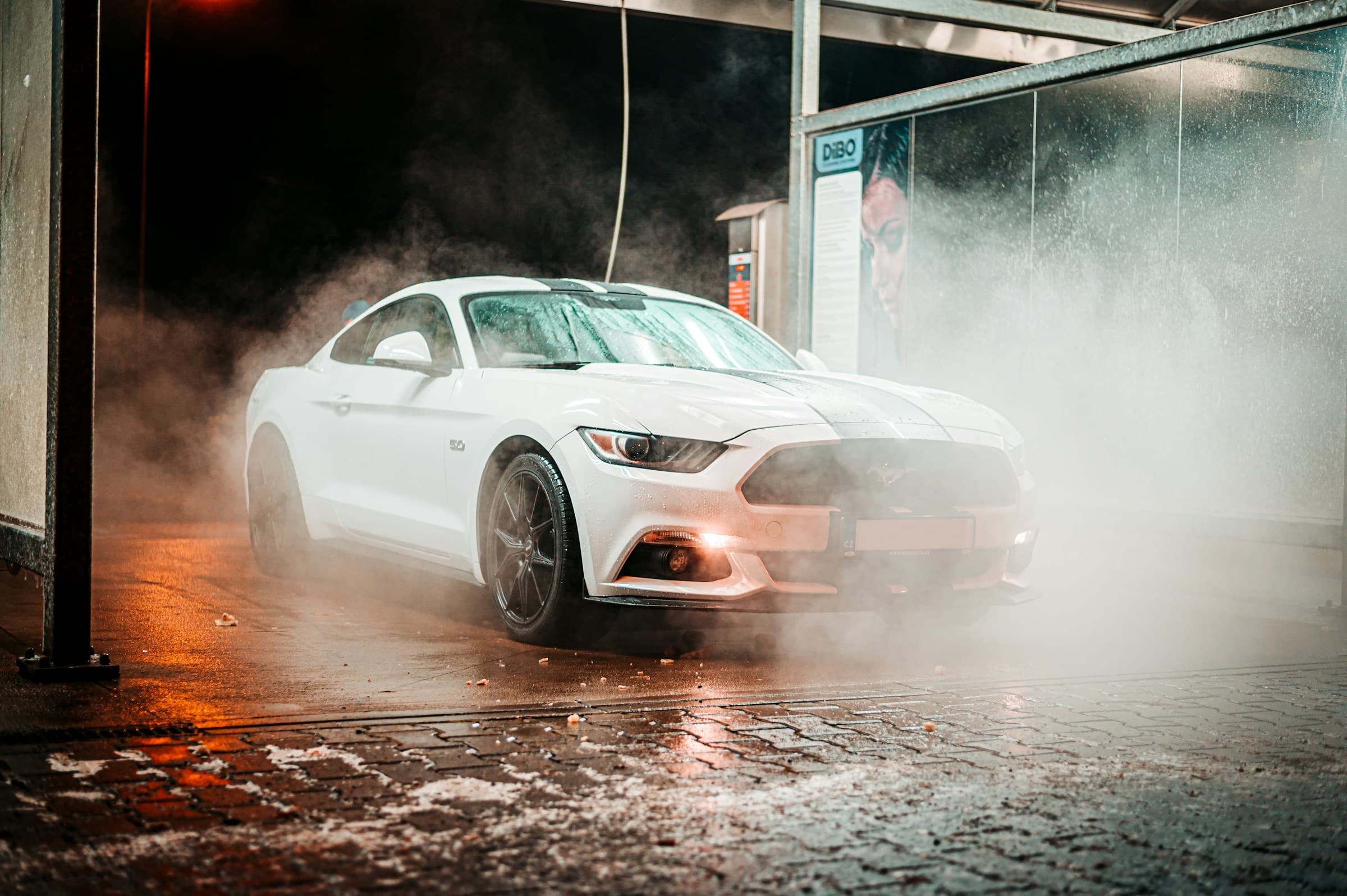 A white sports car being washed at night